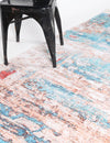 Multicolored patterned rug with a black chair on a white background