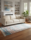 Living room with a beige sofa, rug, and decorative items.