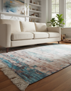 Beige sofa in a living room with a patterned rug on the floor.
