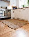 Kitchen with a woven rug on wooden flooring