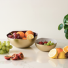 Fruit bowls with various fruits on a light surface