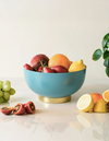 Blue bowl with fruits on a light surface