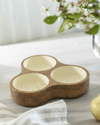 Wooden dish with three compartments on a table with a pear and flowers in the background