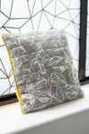 Gray floral-patterned cushion with yellow edge on a windowsill