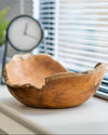 Wooden bowl on a windowsill with blinds in the background