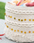 Textured woven basket with decorative elements on a light background