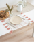 Table setting with a plate, cutlery, and decorative elements on a white tablecloth.