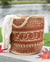 Woven basket with a pattern on a wooden surface near a body of water