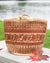 Woven bag with a pattern on a wooden surface with leaves