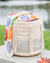 Woven basket with colorful crocheted blanket on a blurred natural background