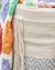 Close-up of a woven basket with colorful crocheted blanket on top