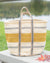 Striped woven basket with handles on a surface outdoors