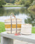 Two woven baskets on a wooden bench by a lake