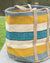 Striped woven basket with handles on a blurred outdoor background