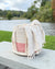 Textile basket with a towel draped over it by a lake