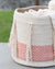 Woven basket with chevron pattern and tassels on a blurred natural background