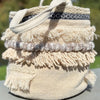 Beige woven basket with decorative elements on a blurred natural background