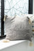 Gray pillow with 'home sweet home' text on a windowsill.