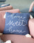 Blue pillow with 'home sweet home' text on a pink couch