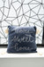 Blue pillow with 'home sweet home' text on a geometric patterned wall background