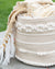 Textile roll with decorative white beads and a yellow fabric on a blurred green background