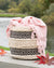 Woven basket with a pink scarf on a wooden bench by a lake