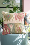 Decorative pillow with floral pattern on a teal chair