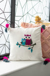 Decorative pillow with owl design on a windowsill with geometric wall pattern