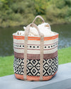 Woven basket with patterned design on a surface outdoors