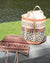 Woven bags with geometric patterns on a wooden surface by a body of water.
