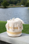Macrame basket with tassels on a wooden surface by a body of water