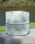 Decorative woven basket with striped pattern on a wooden surface outdoors.