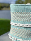 Close-up of a woven basket with a patterned design against a blurred natural background