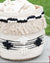 Woven basket with black and white decorative elements on a grassy background