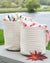Two woven baskets with colorful blankets on a wooden surface near a body of water.
