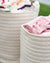 Two woven baskets with colorful and pink fabrics inside, placed outdoors.