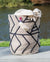 Textile bag with geometric pattern on a wooden surface by a body of water