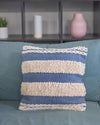 Decorative pillow with blue and beige stripes on a teal couch