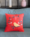 Red pillow with a bird design on a gray couch