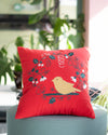 Red pillow with a bird design on a gray chair in an outdoor setting