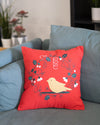 Red pillow with a bird design on a blue couch
