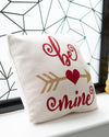 Decorative pillow with 'I love mine' text and heart design on a window sill.