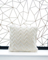 White pillow with a zigzag pattern against a geometric wall design