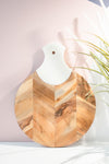 Wooden cutting board with marble handle on a light background